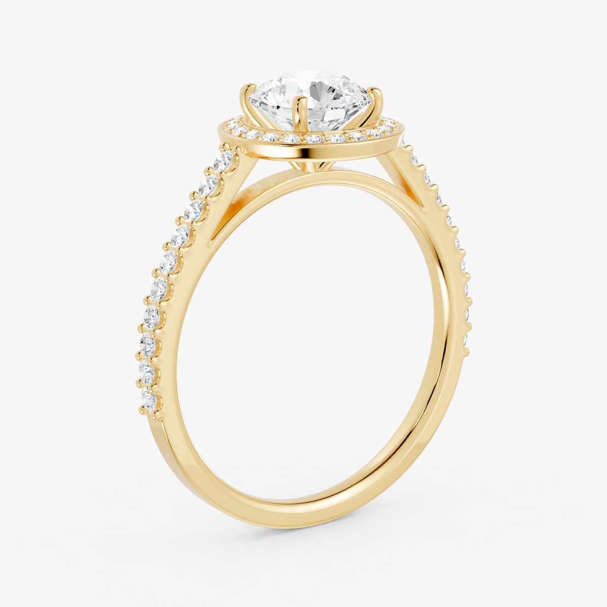 Coralie halo forlovelsesring med rund diamant og pavé i gult gull, skrått fra siden