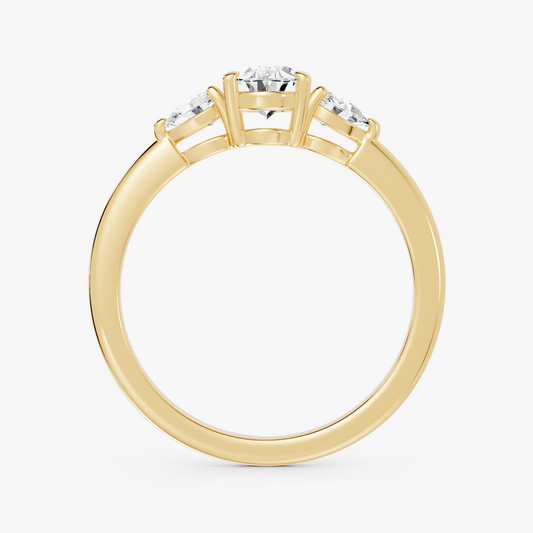 Delphine trestens forlovelsesring med oval diamant og to pæreformede sidesteiner i gult gull, stående rett forfra
