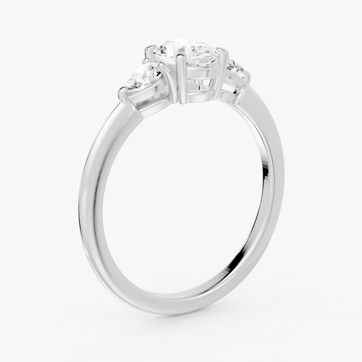 Delphine trestens forlovelsesring med oval diamant og to pæreformede sidesteiner i hvitt gull, skrått fra siden