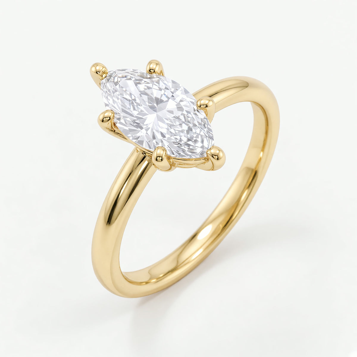 Colette solitaire forlovelsesring med marquise diamant i gult gull, sett fra siden på skrå
