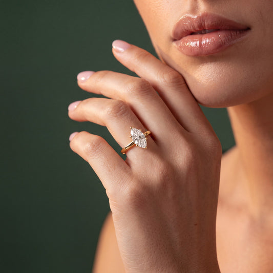 Colette solitaire forlovelsesring med marquise diamant i gult gull, båret på hånd