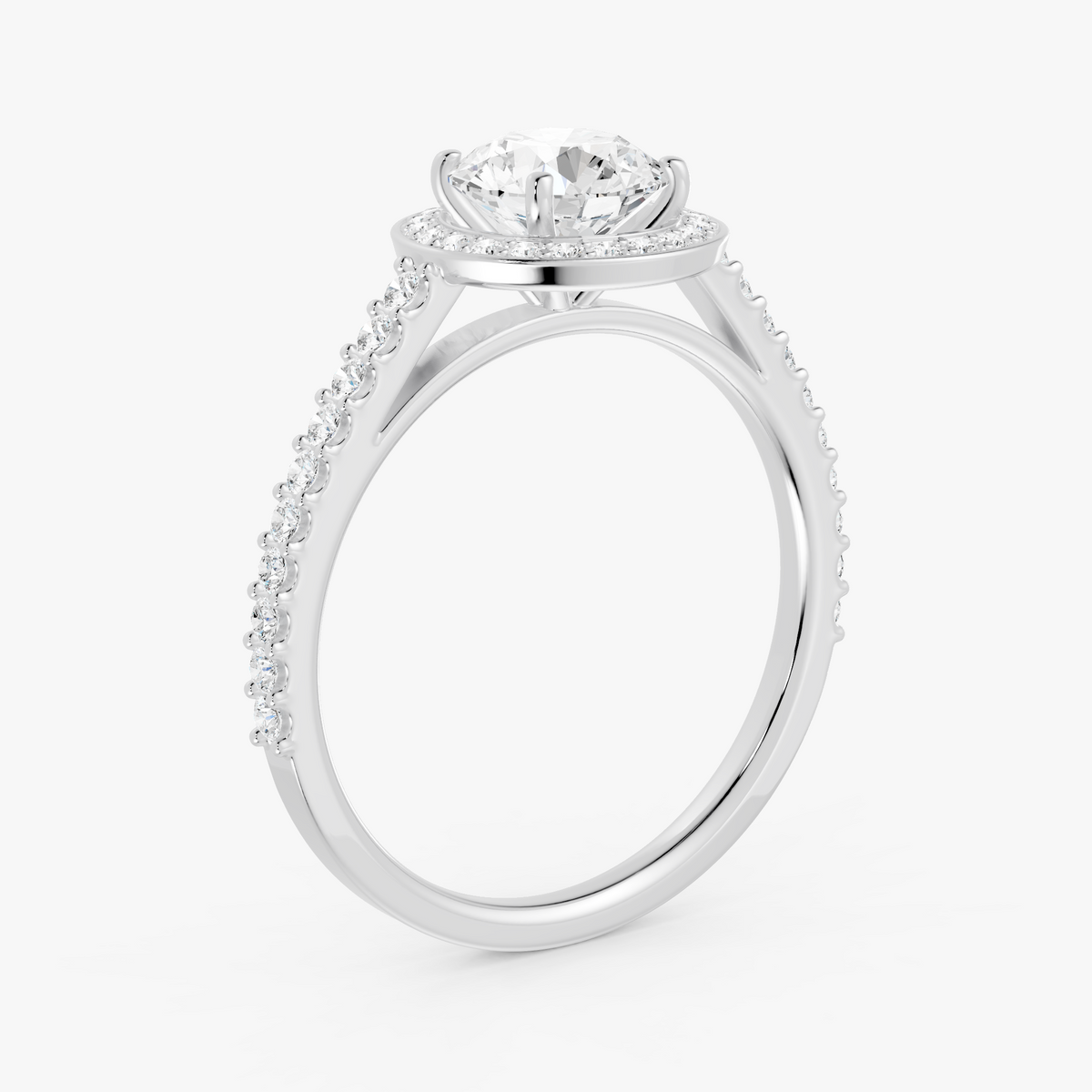Coralie halo forlovelsesring med rund diamant og pavé i hvitt gull, skrått fra siden