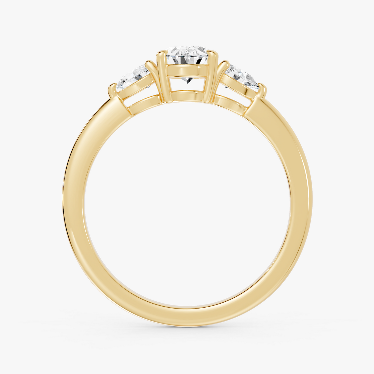 Delphine trestens forlovelsesring med oval diamant og to pæreformede sidesteiner i gult gull, stående rett forfra