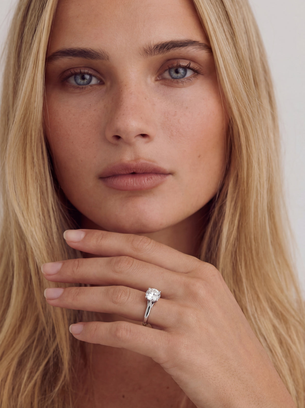 Celestine solitaire forlovelsesring med rund briljant i hvitt gull båret på modell