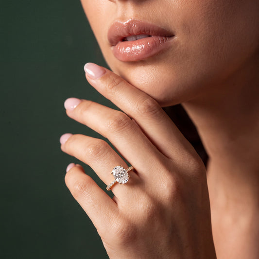 Seraphine pavé forlovelsesring med oval diamant i gult gull, båret på hånd