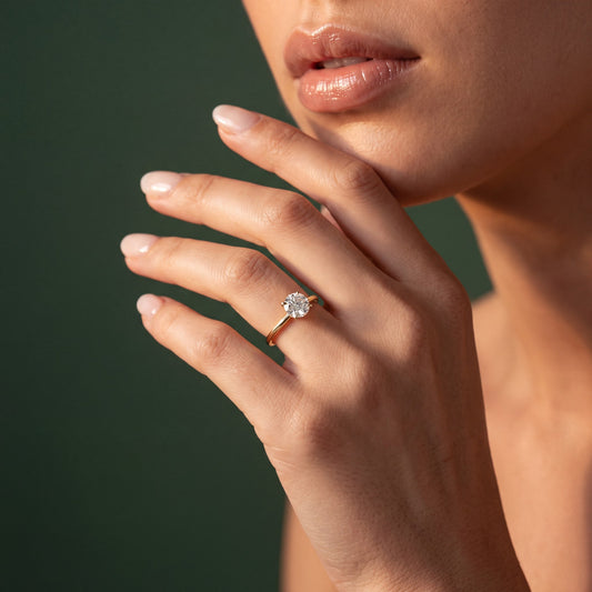 Vivienne solitaire forlovelsesring med rund diamant i gult gull, båret på hånd